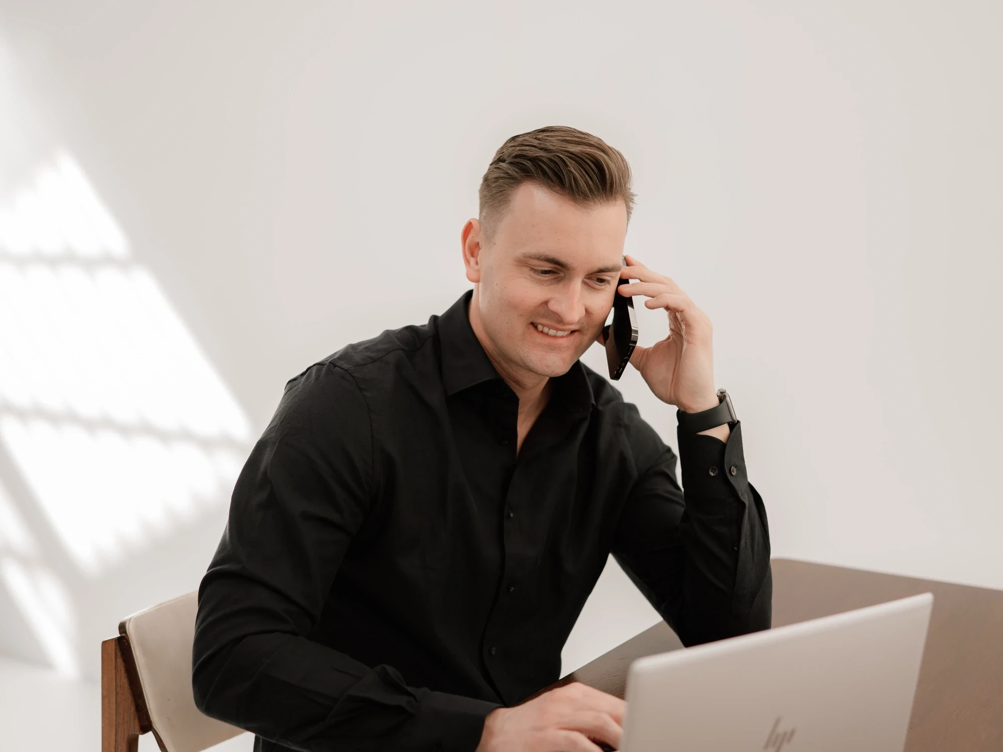 Robert-Paul, oprichter van Zeeuwsweb, aan de telefoon achter zijn laptop in de studio