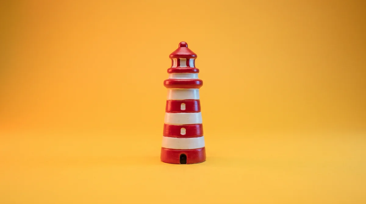 Een rood-witte vuurtoren op een gele achtergrond, als beeld bij online marketing in Zeeland