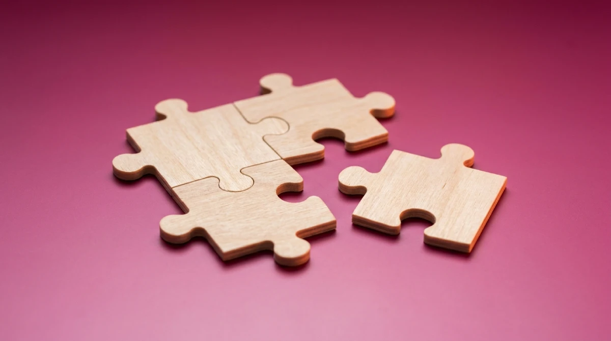 Drie houten puzzelstukjes die in elkaar passen en een vierde ernaast, als beeld bij SEO werkzaamheden